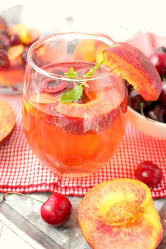 Craving a wonderfully refreshing fruity cocktail? My Easy Peach & Cherry Sangria is the perfect drink to mix for a party, shower or summer cookout. Just a few simple ingredients are needed for a pitcher of this fantastic summer libation!