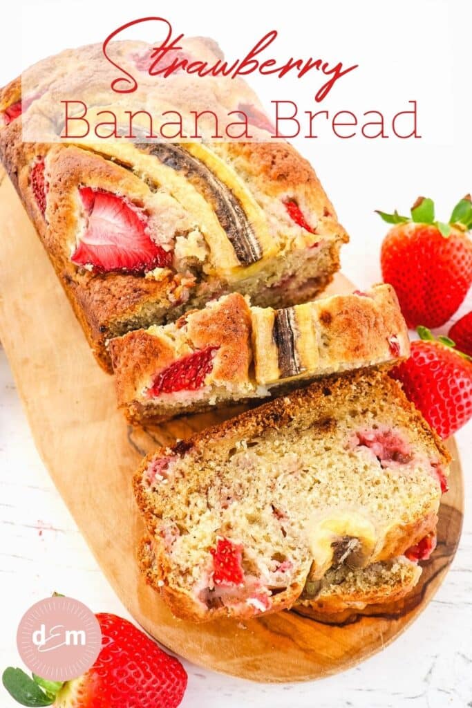 Loaf of sliced strawberry banana bread, garnished with fresh strawberries.