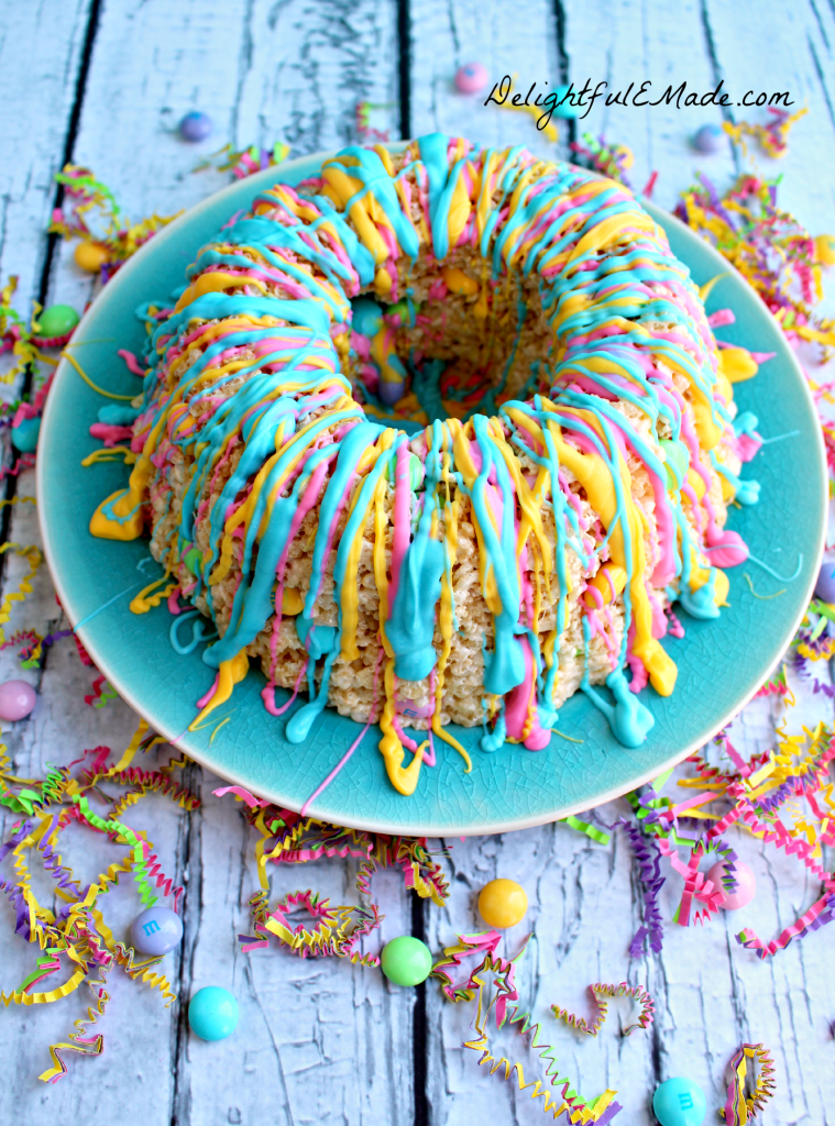 This rice krispie cake recipe will be your new favorite spring treat!   Super easy to make, this rice krispie cake is made in a bundt pan, and loaded with colorful spring M&M's candies, and drizzled with pretty pastel candy melts.