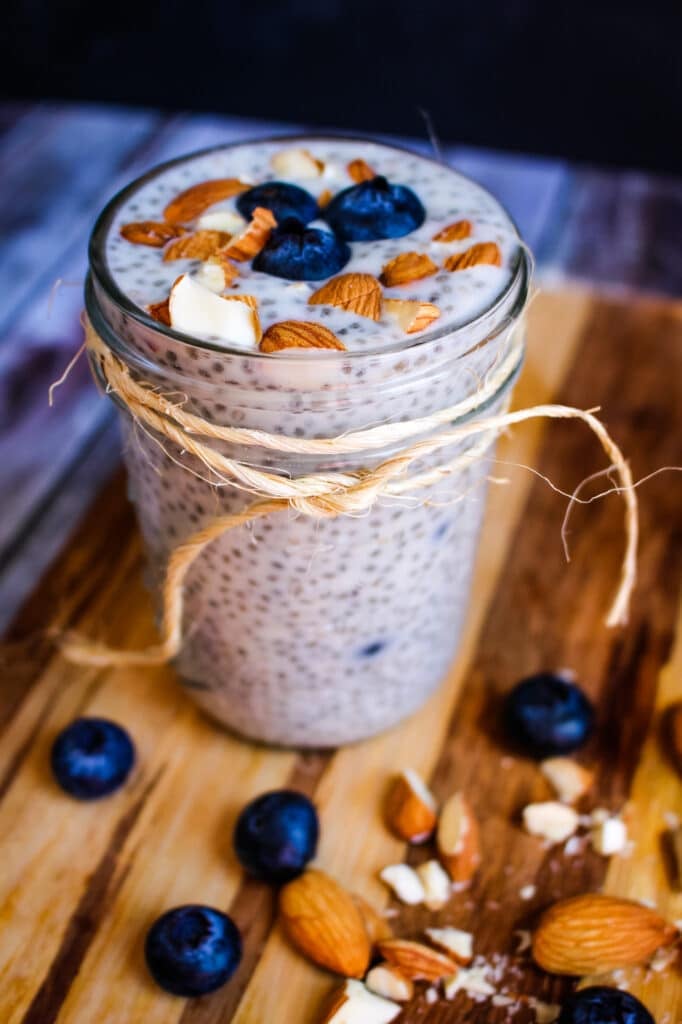 Blueberry chia seed pudding recipe in mason jar topped with fresh blueberries and chopped almonds.