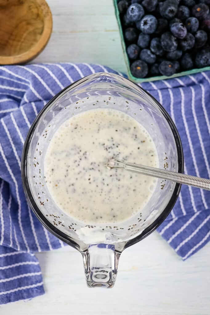 Blueberry chia pudding recipe mixed together in a mixing bowl with a whisk.