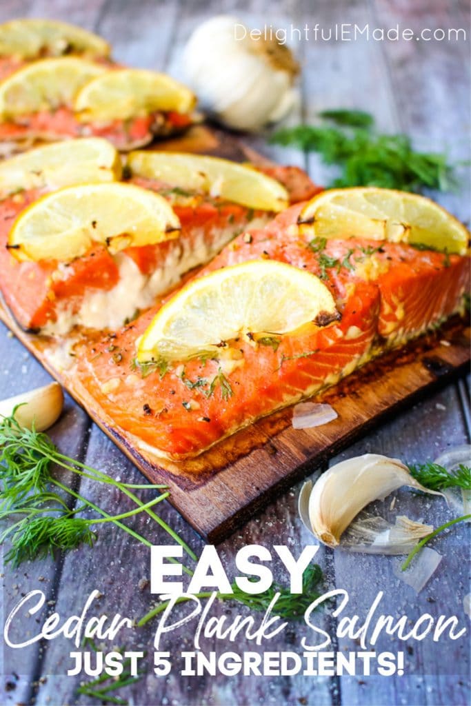 Grilled Cedar Plank Salmon on charred plank, topped with dill, garlic and lemon slices.