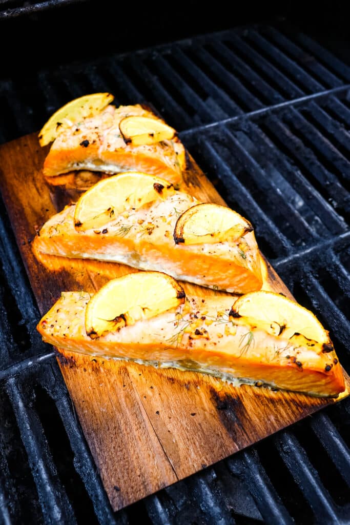 Cedar plank salmon cooking on the grill.