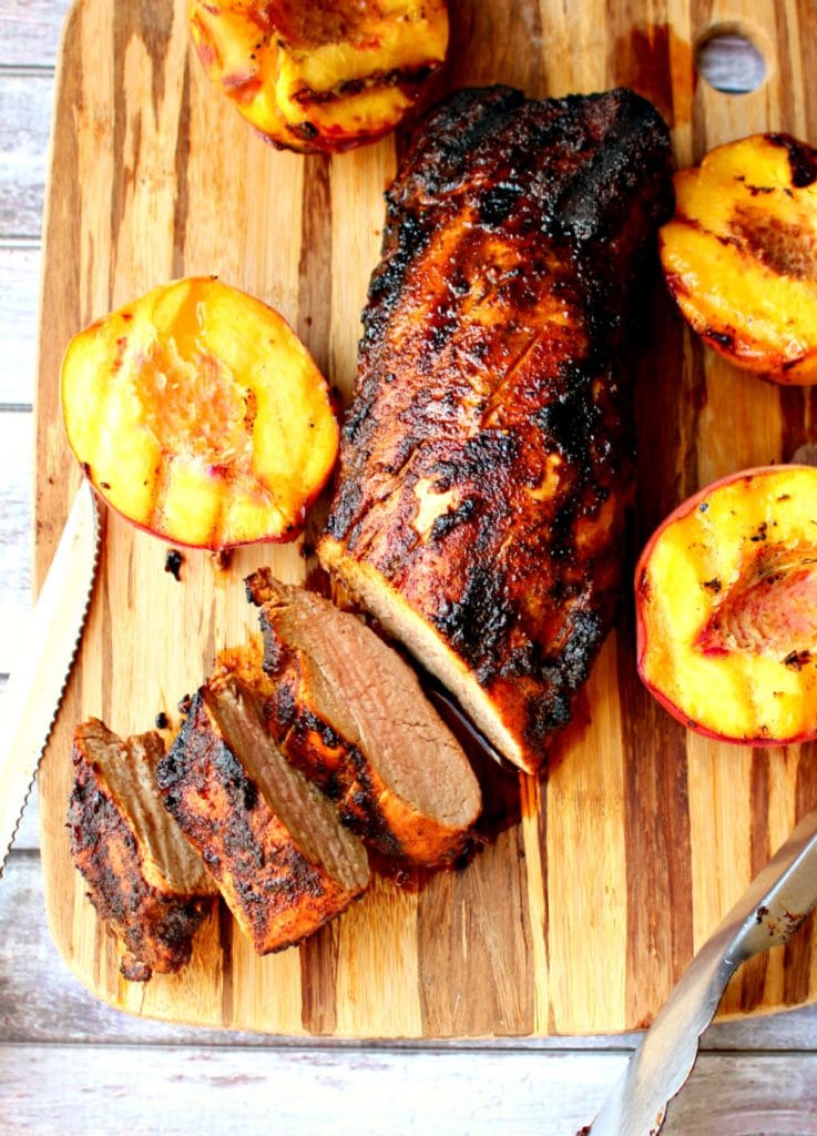 Grilled pork loin recipe, sliced on board with grilled peaches.