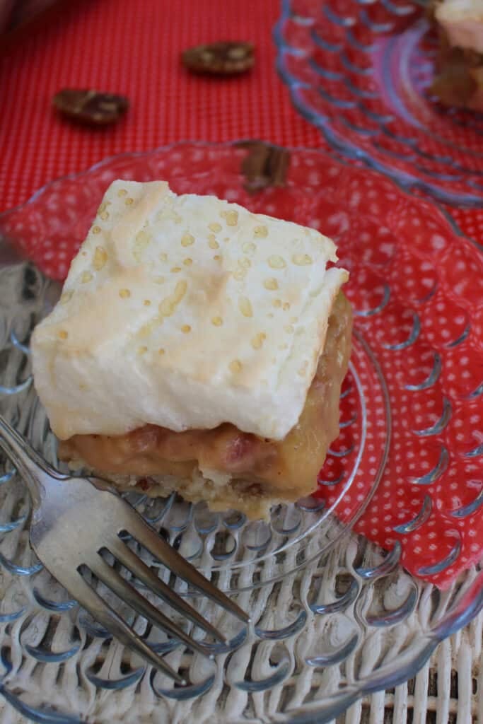A slice of rhubarb delight on a plate with a fork on the side.