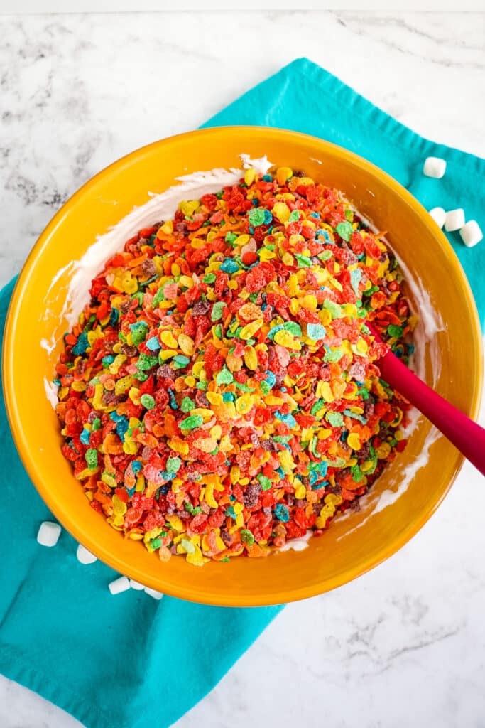 Melted marshmallow with Fruity pebbles cereal poured on top to make fruity pebbles treats.
