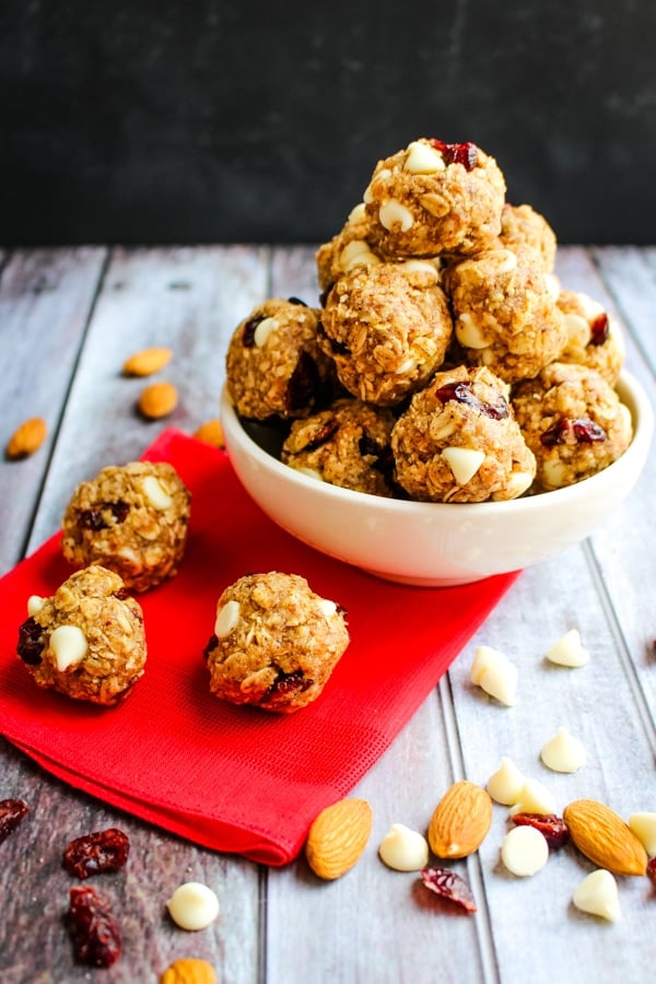 Bowl of cranberry no bake energy bites, with 3 bites on a red napkin.