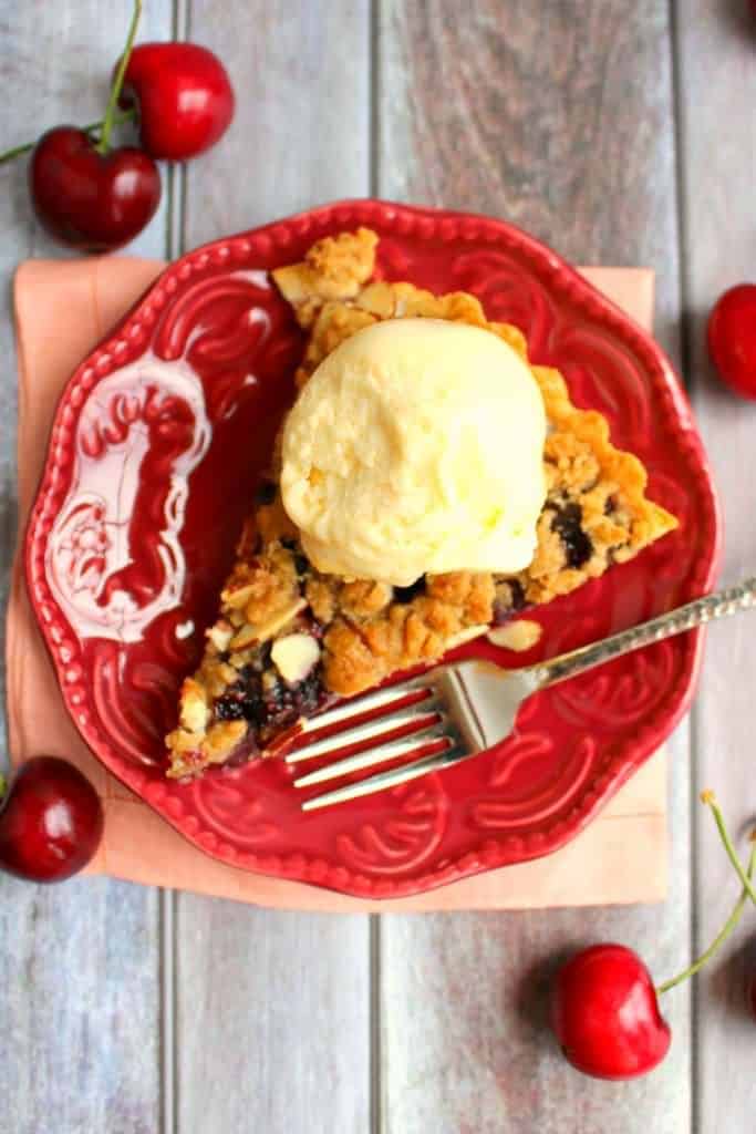 Even easier than Cherry Pie, this Cherry Almond Crumble Tart is fabulous! Loaded with fresh cherry flavor, this super-simple tart recipe, uses store-bought pie crust, along with fresh or frozen cherries. Makes an amazing Thanksgiving or Christmas dessert or just a simple weeknight treat!