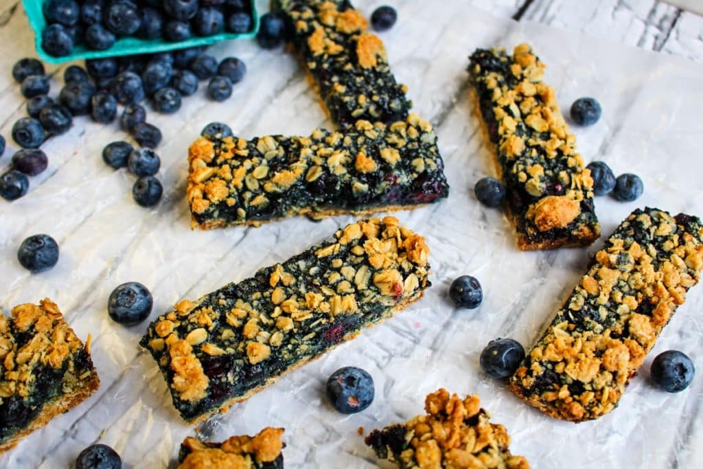 Blueberry crumble bars cut into long bars and garnished with fresh blueberries.