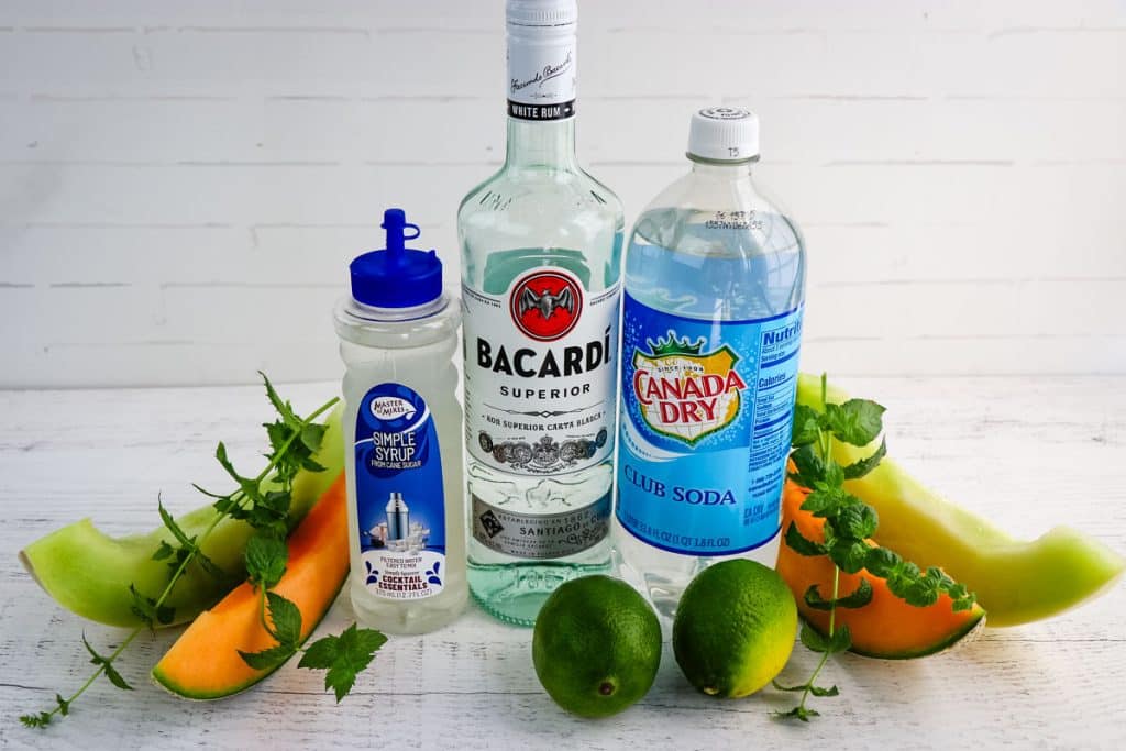 Ingredients needed to make a melon mojito, include fresh melon, mint leaves, lime juice, Rum, simple syrup and club soda.