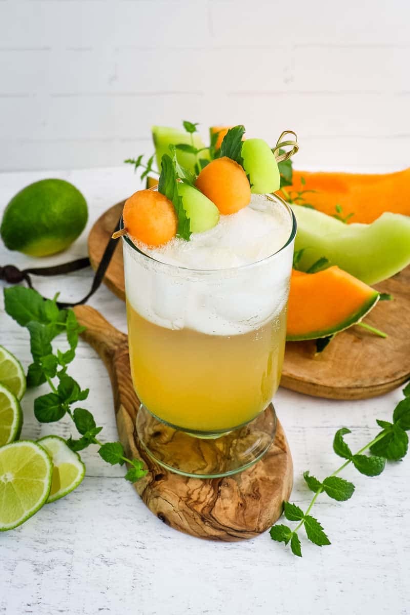 Melon mojito garnished with melon balls and fresh mint leaves.