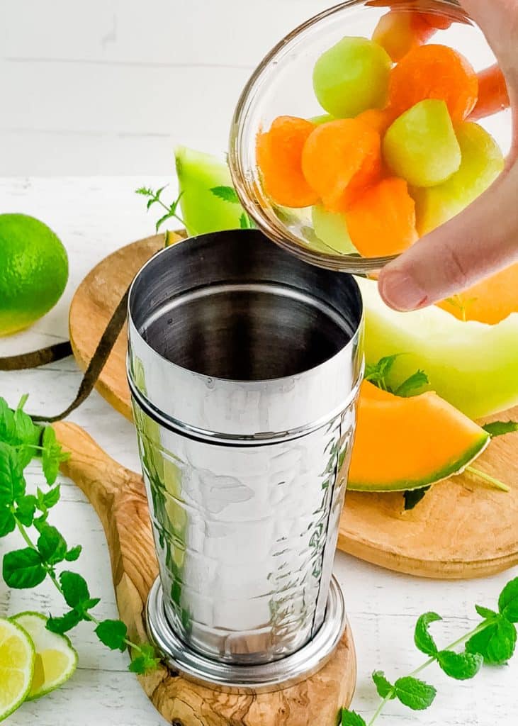 Melon balls being poured into a cocktail shaker.