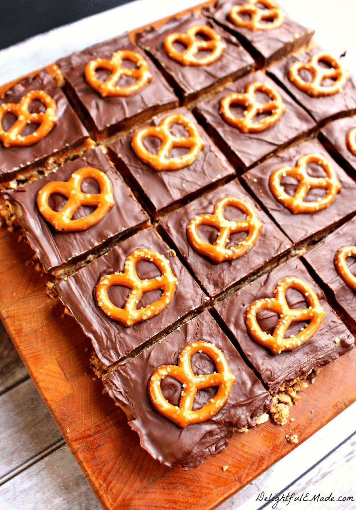 Anyone that loves a sweet & savory treat will love these bars! A pretzel pecan crust is topped with dark chocolate chips, caramel and topped with more dark chocolate and a pretzel. 