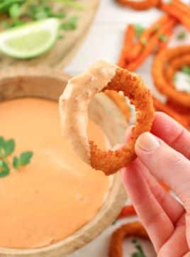 Onion ring that has been dipped in a chipotle sauce recipe.