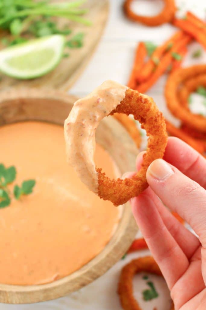 Onion ring that has been dipped in a chipotle sauce recipe.