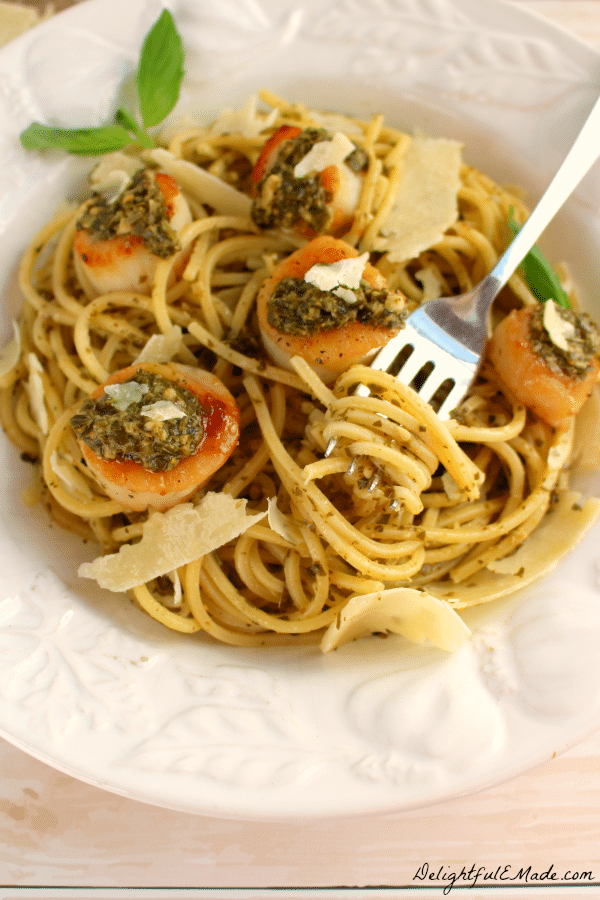 Spaghetti alla Chitarra pasta is paired with pesto sauce, pan seared sea scallops and fresh Parmesan Reggiano cheese for a wonderfully delicious meal!  