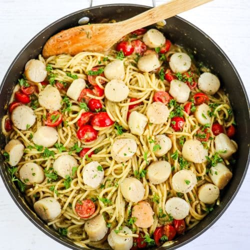 Seared scallops added to the pesto and pasta with tomatoes.