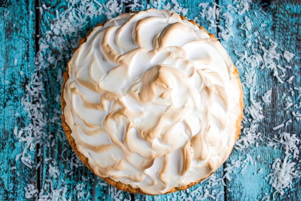 Whole, unsliced Coconut cream pie with browned meringue topping.