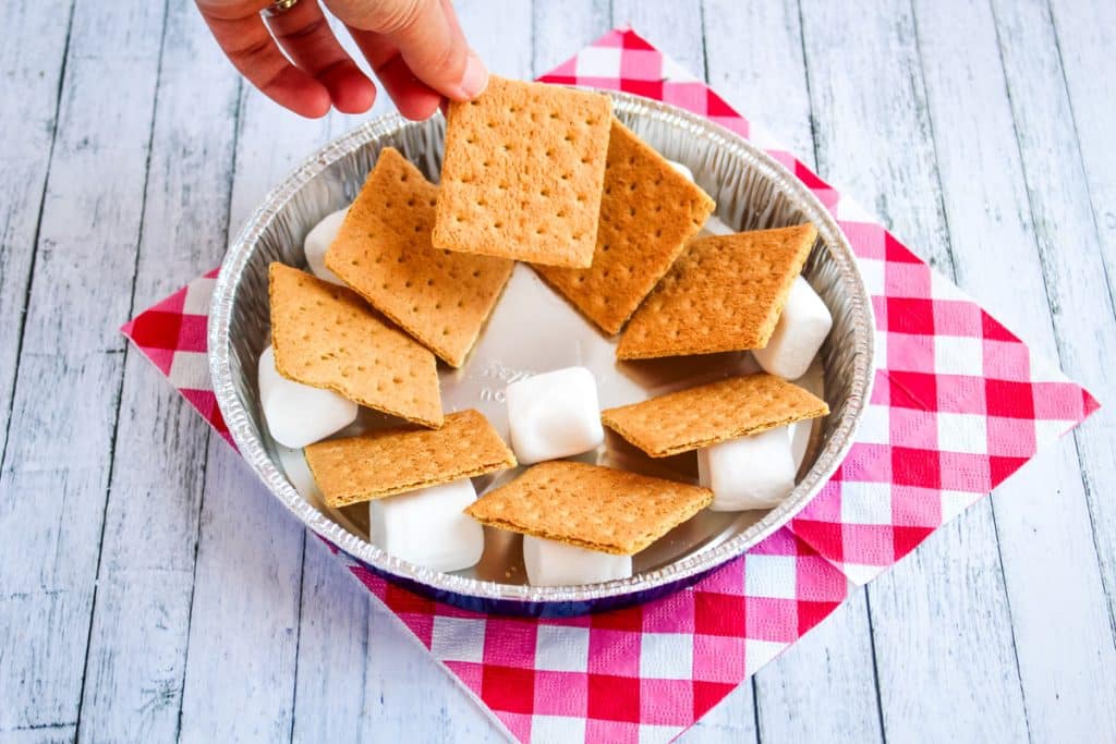 Smores in pan with large marshmallows and graham crackers layered together.