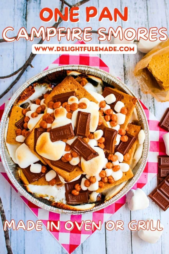 One pan campfire smores nachos in a round pan with caramel bits, and sticks with marshmallows on the side for decoration.