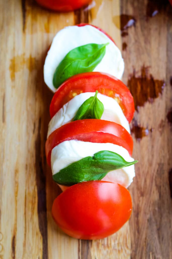 Fresh basil leaves, sliced tomatoes and fresh mozzarella for topping the grilled caprese chicken.