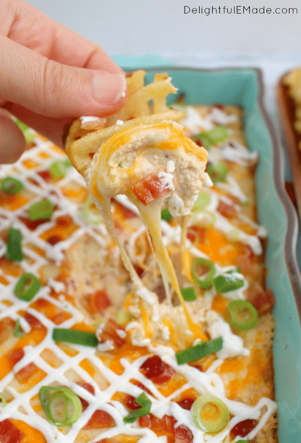 All of the amazing toppings on a loaded baked potatoes in one hot, glorious dip! Served with potato wedges and waffle fries, this hot, cheesy appetizer is one that everyone will love when watching the big game!
