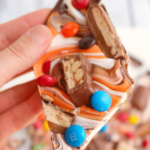 The perfect way to enjoy all your favorite candy in one glorious bite! My Halloween Candy Bark is made with delicious chocolate, white and orange candy melts, and bejeweled with loads of candy! A great treat to add to any Halloween Boo basket!