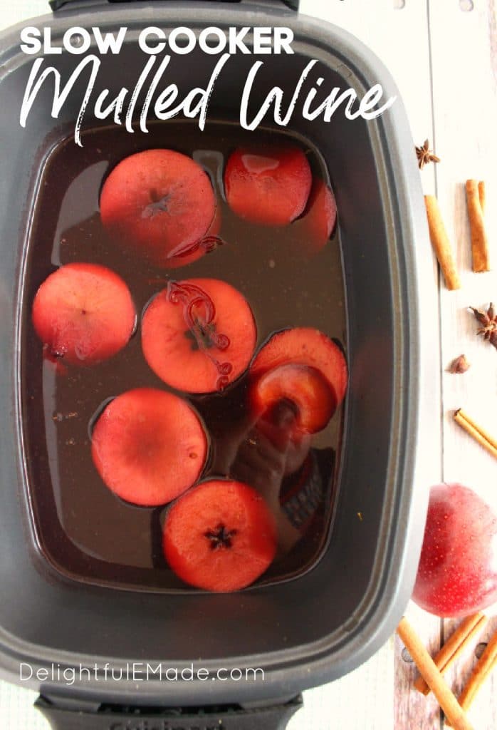 Slow cooker mulled wine in crock pot, with apple slices.