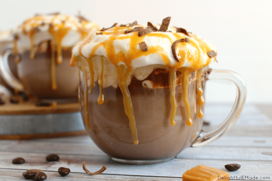 mocca in cup with whipped cream, caramel and chocolate shavings on top