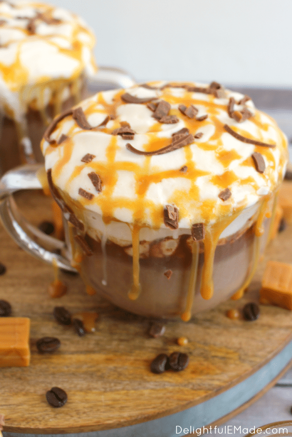 Homemade Starbucks salted caramel mocha in mug topped with caramel, whipped cream and chocolate curls.