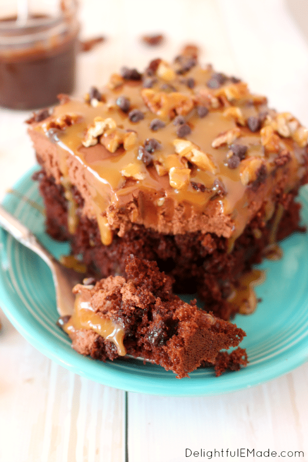 The classic Turtle candy, made into a glorious poke cake! Devils food cake is drizzled with hot fudge, layered with thick chocolate frosting and then topped with pecans, chocolate and caramel for the most amazing cake!