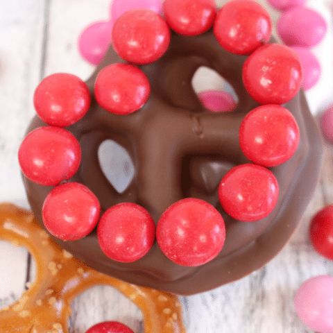 The ultimate salty-sweet treat for your Valentine's! These delicious homemade chocolate covered pretzels are simple to make with just a few simple ingredients! Decorated with Strawberry M&M's® and paired with a gorgeous DOVE® Valentine's Day tin and American Greetings® Valentine's Day cards, these jumbo pretzels make for the sweetest surprise for your sweethearts!