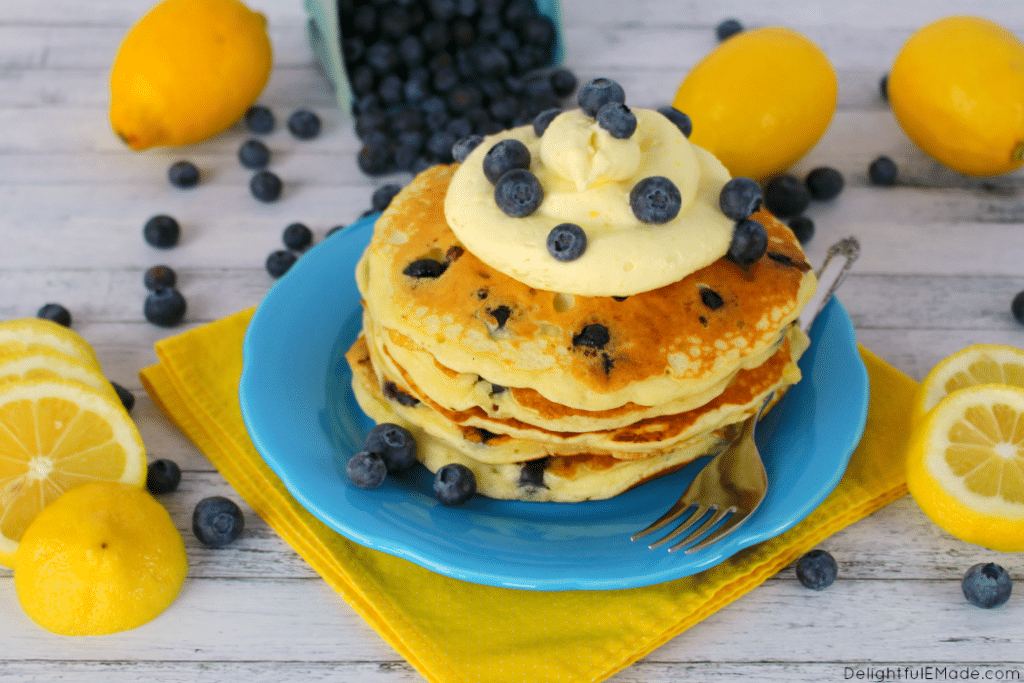 The fresh, delicious flavors of lemon and blueberry come together in these fluffy Lemon Blueberry Pancakes.  Topped with a delicious lemon cream cheese whipped topping, and fresh blueberries, these make for an amazing breakfast or brunch!