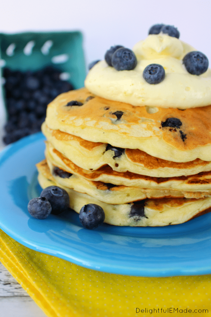 The fresh, delicious flavors of lemon and blueberry come together in these fluffy Lemon Blueberry Pancakes.  Topped with a delicious lemon cream cheese whipped topping, and fresh blueberries, these make for an amazing breakfast or brunch!