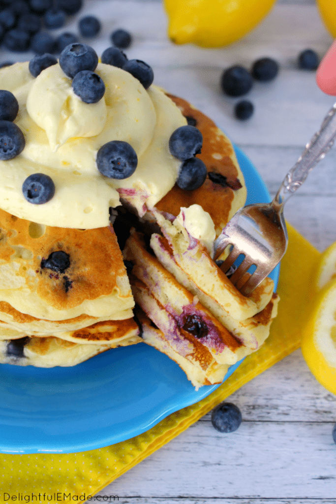 The fresh, delicious flavors of lemon and blueberry come together in these fluffy Lemon Blueberry Pancakes.  Topped with a delicious lemon cream cheese whipped topping, and fresh blueberries, these make for an amazing breakfast or brunch!