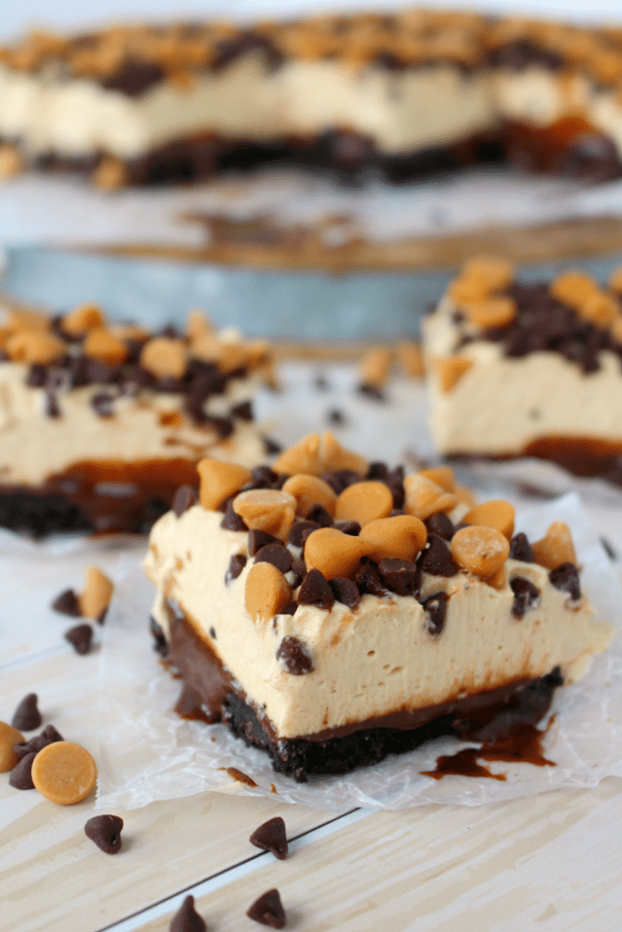These Chocolate Peanut Butter Cheesecake Bars are a chocolate and peanut butter lovers dream!  Made with an OREO crust, hot fudge, dreamy peanut butter mousse and topped with peanut butter chips, these no bake cheesecake bars are cool, creamy and completely delicious!