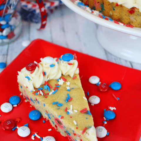 An amazing Red, White and Blue dessert, perfect for celebrating America! Chewy, delicious sugar cookie dough made with M&M's® Red, White, & Blue Milk Chocolate candies, stars and stripes sprinkles, and topped with buttercream frosting, makes for the ultimate patriotic treat! Fantastic for Memorial Day and 4th of July picnics and celebrations!