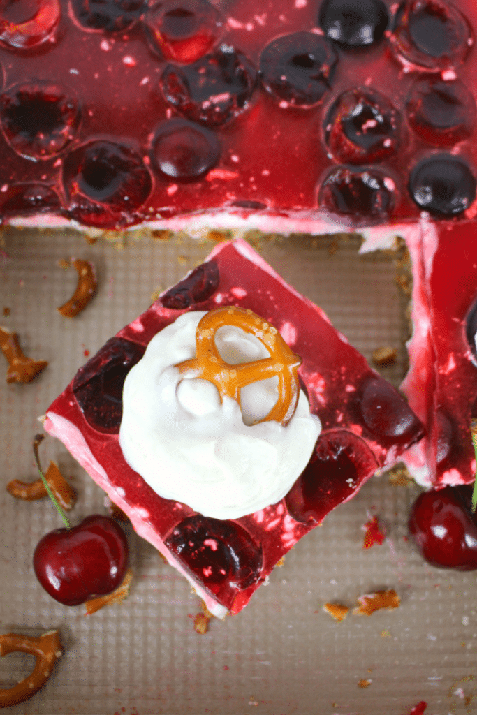 Amazing as a salad or dessert, this incredible Cherry Jello Pretzel Salad is the ultimate side dish for any cookout, potluck or backyard barbecue! Made with a salty-sweet pretzel crust, a delicious cream cheese filling, and topped with fresh cherries in jello, this salad is a must for any summer get-together. Even better than the strawberry version!