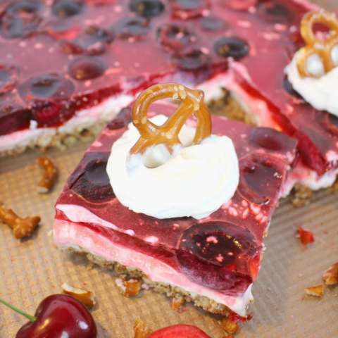 Amazing as a salad or dessert, this incredible Cherry Jello Pretzel Salad is the ultimate side dish for any cookout, potluck or backyard barbecue! Made with a salty-sweet pretzel crust, a delicious cream cheese filling, and topped with fresh cherries in jello, this salad is a must for any summer get-together. Even better than the strawberry version!