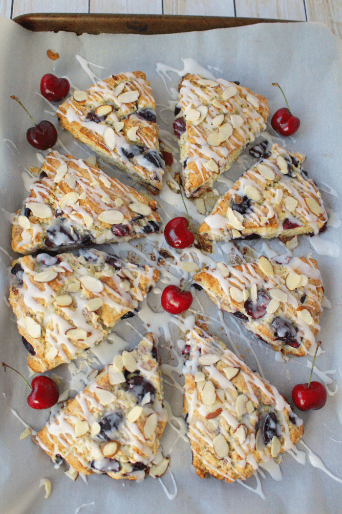 Cream Cheese Cherry Almond Scones on pan with fresh cherries.