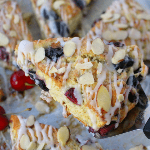 Stuffed with fresh cherries, sliced almonds, and drizzled with a cream cheese glaze, these flaky scones are fantastic with your morning coffee! Perfect for breakfast, this super-easy scone recipe uses butter, along with cream cheese to keep the dough wonderfully moist and tender, and completely delicious!