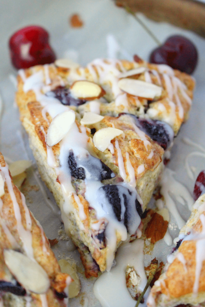 Stuffed with fresh cherries, sliced almonds, and drizzled with a cream cheese glaze, these flaky scones are fantastic with your morning coffee! Perfect for breakfast, this super-easy scone recipe uses butter, along with cream cheese to keep the dough wonderfully moist and tender, and completely delicious!