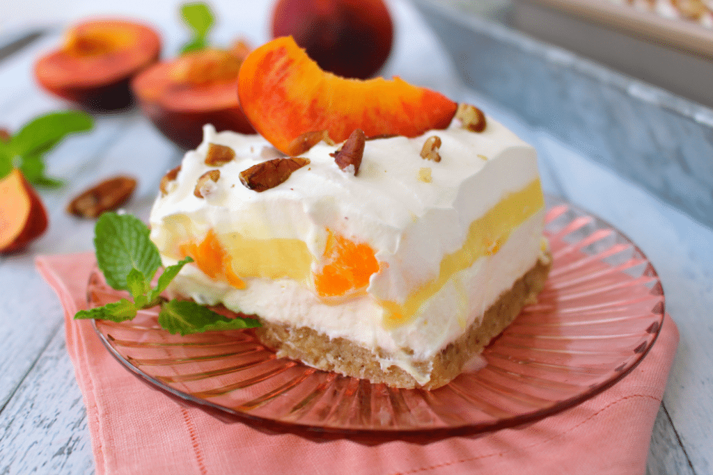 If you love fresh, summer peaches this dessert is for you! My Peaches & Cream Dessert Bars have a Pecan Sandie cookie crust, cream cheese filling, fresh peaches and toasted pecans! You don't have to be a Southerner to enjoy this fabulous dessert!