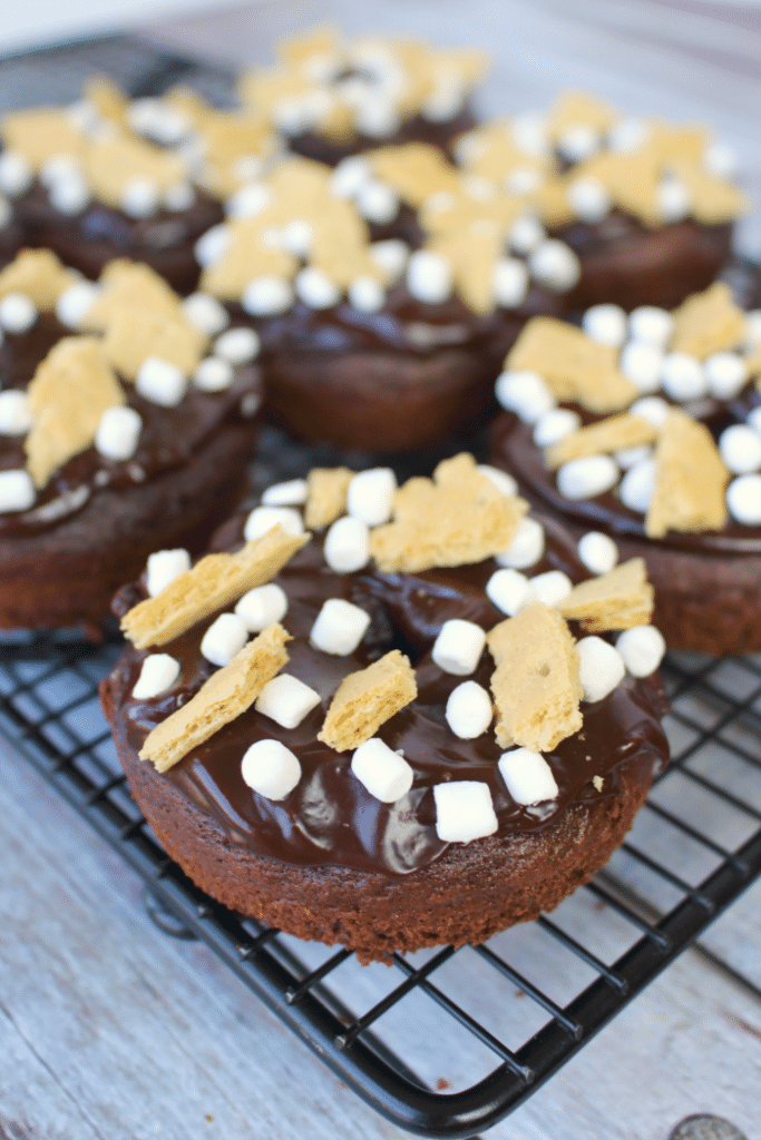 The classic campfire snack turned into a breakfast treat! These delicious Chocolate S'mores Donuts are simply baked in a donut pan, topped with a chocolate ganache frosting and sprinkled with marshmallows and graham crackers! These will be a new favorite anytime you're in the mood for something sweet!