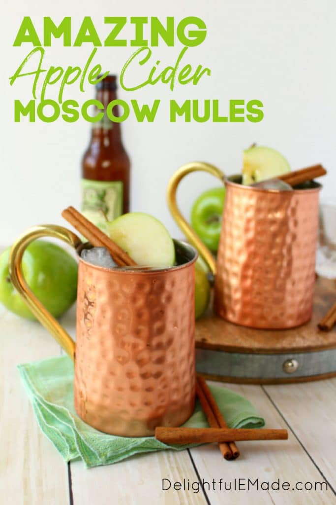 Apple Cider Moscow Mules, in copper mugs, garnished with apple slices and cinnamon sticks.