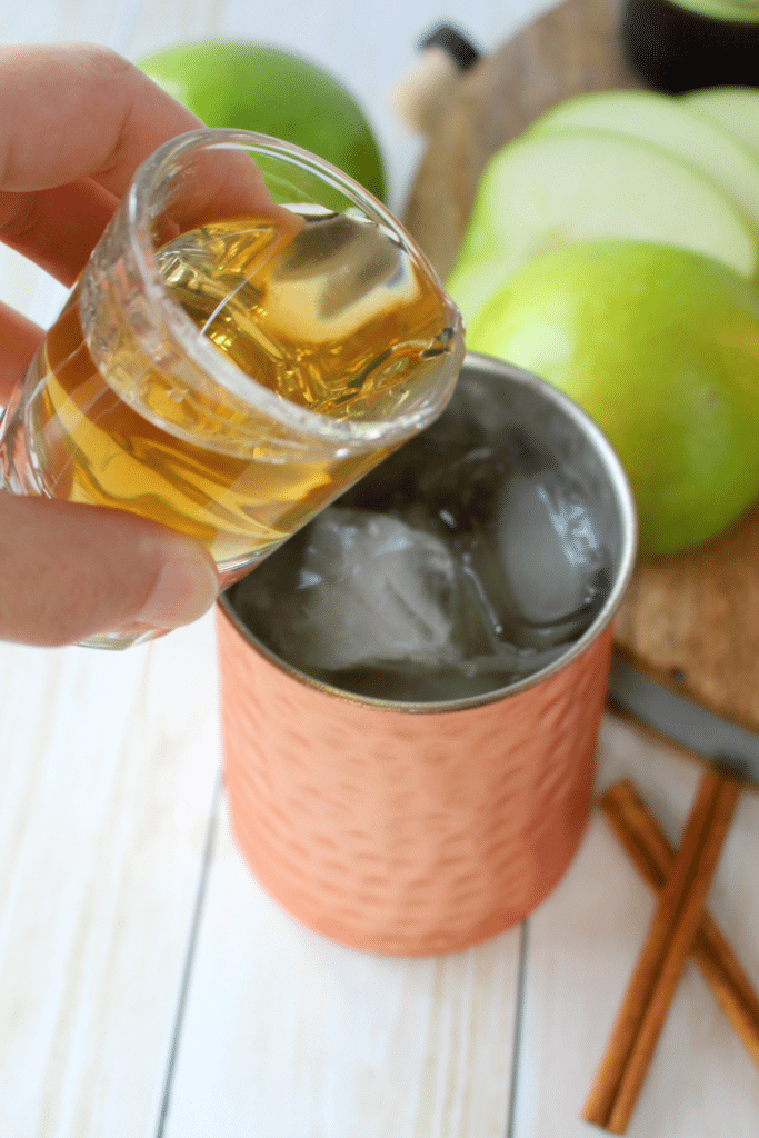 The perfect apple cocktail to enjoy on a crisp autumn day! My Apple Ginger Moscow Mule is made with spiced apple cider, Ginger liqueur, Ginger beer, and topped with a fresh, crisp Granny Smith Apple slice! How 'bout them apples?!