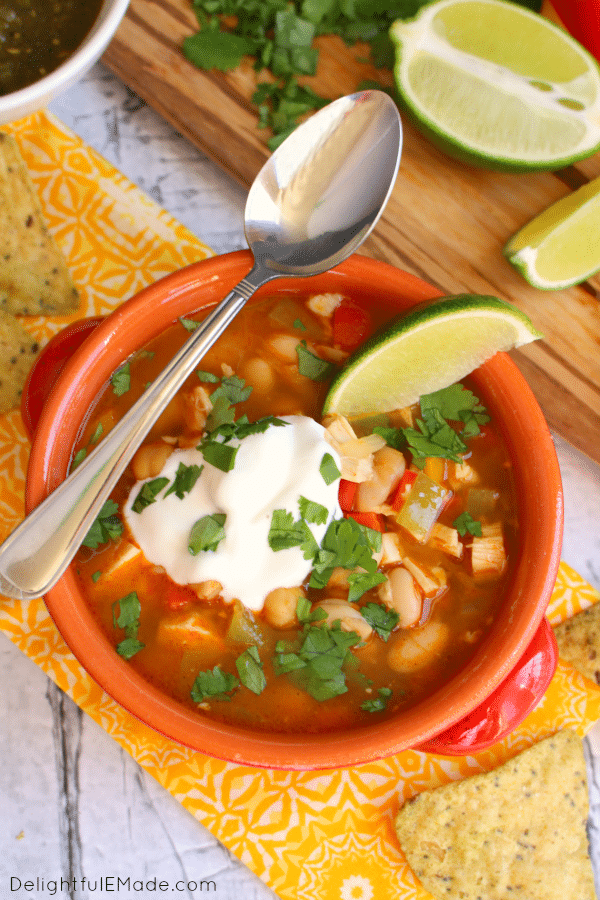 Lime chili chili with dollop of sour cream and lime wedge.