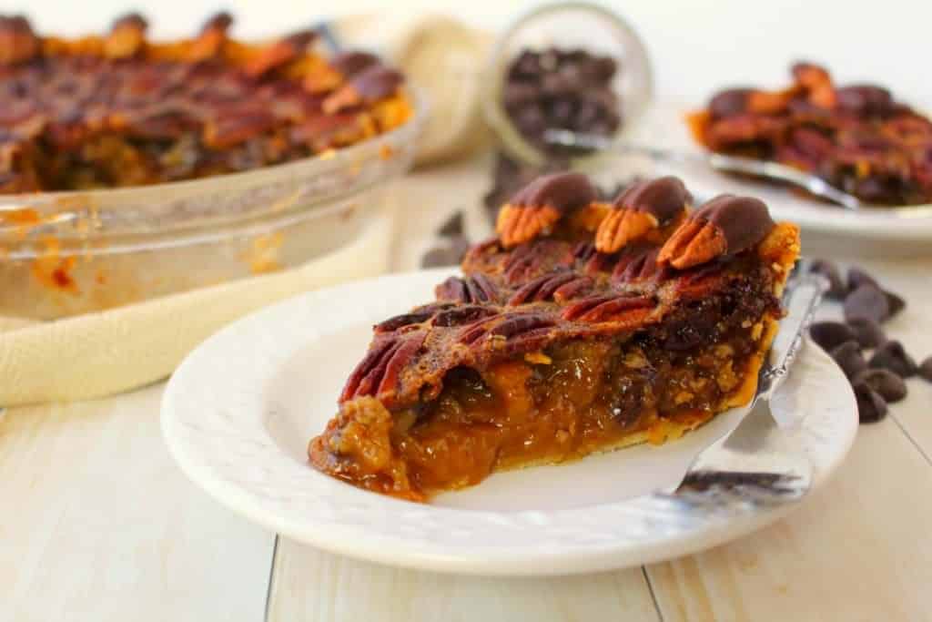 Your favorite pie recipe made even more decadent and delicious!  This Dark Chocolate Pecan Pie recipe is topped with chocolate covered pecans for a show-stopping dessert and is perfect for your Thanksgiving or Christmas dessert table!