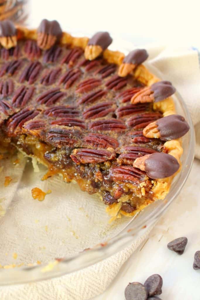 Your favorite pie recipe made even more decadent and delicious!  This Dark Chocolate Pecan Pie recipe is topped with chocolate covered pecans for a show-stopping dessert and is perfect for your Thanksgiving or Christmas dessert table!