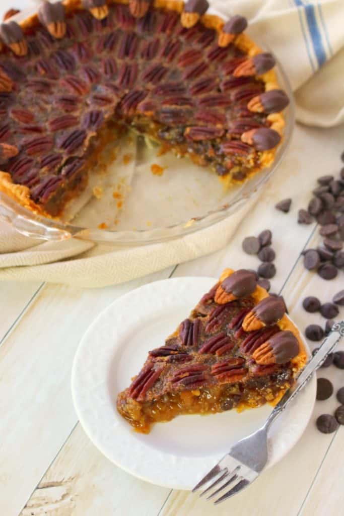 Your favorite pie recipe made even more decadent and delicious!  This Dark Chocolate Pecan Pie recipe is topped with chocolate covered pecans for a show-stopping dessert and is perfect for your Thanksgiving or Christmas dessert table!